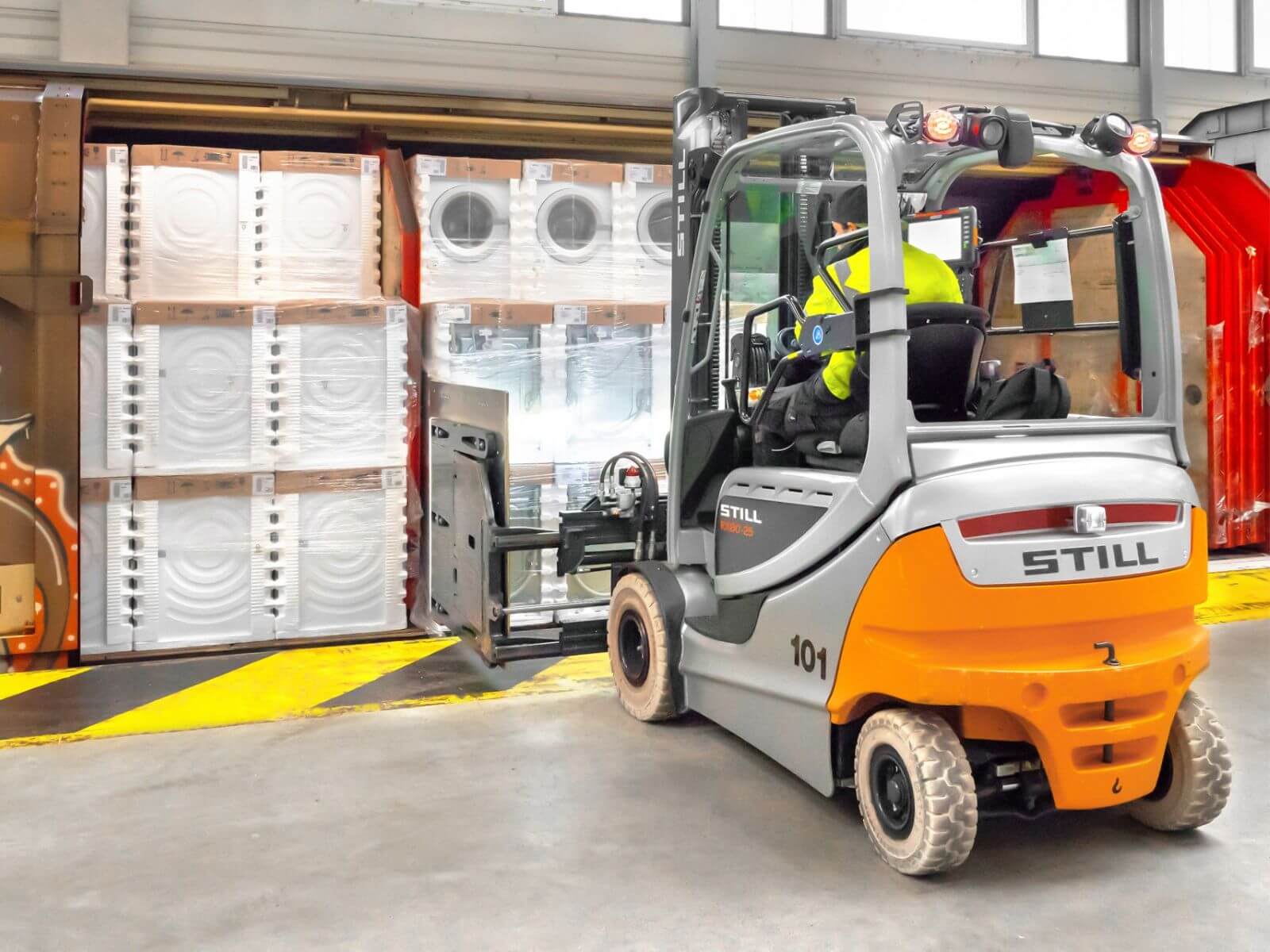 Forklift Operating in Industrial Warehouse A STILL forklift maneuvering a load inside an industrial setting, showcasing efficient material handling operations.