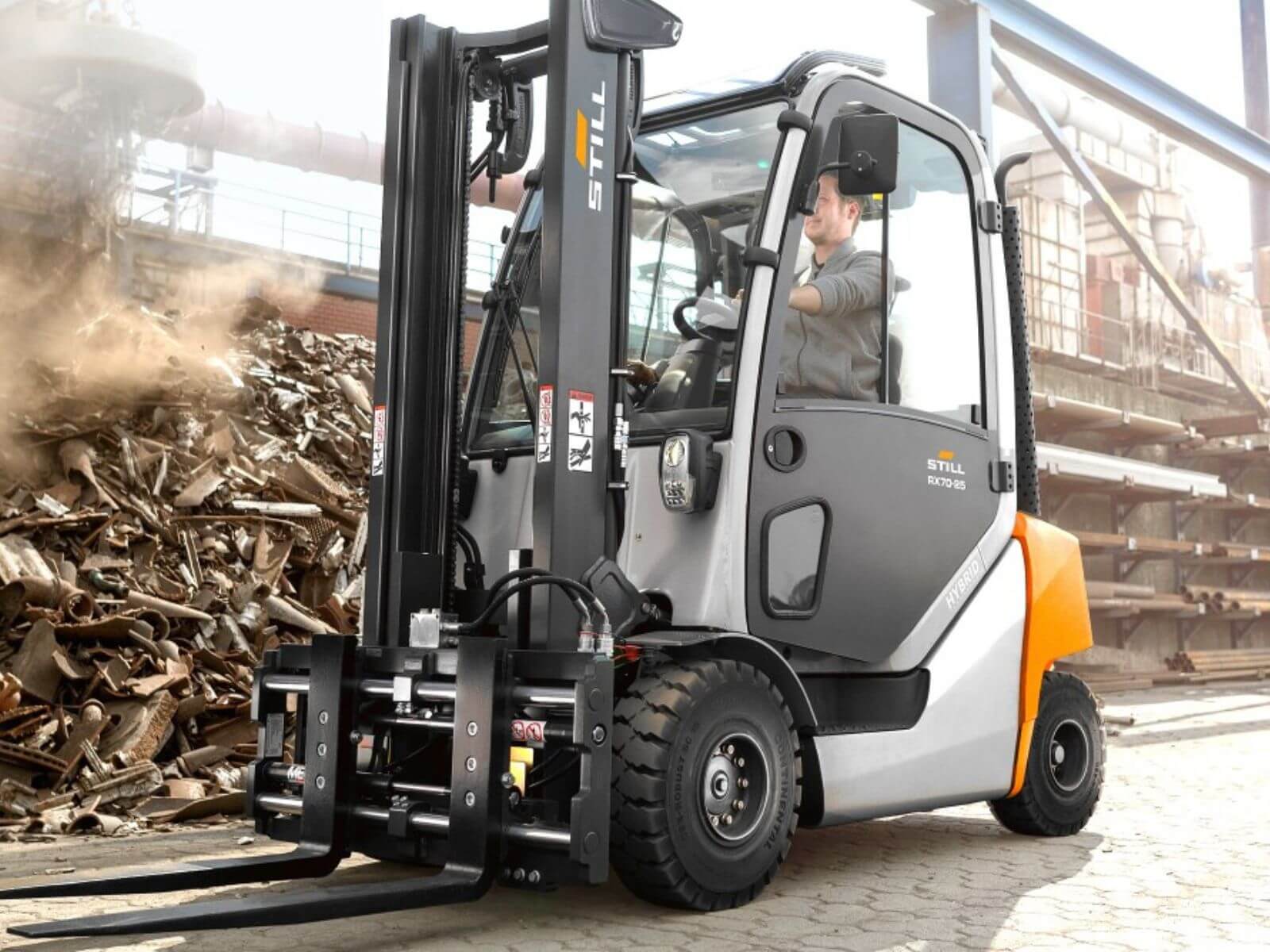 Electric Forklift in Operation at Industrial Site A modern electric forklift lifting materials in a workshop surrounded by piles of scrap metal.