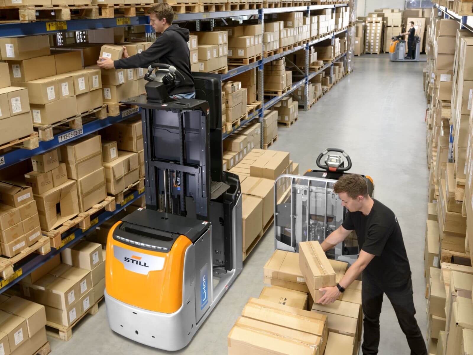 Warehouse Workers Organizing Packages with Forklift Two workers in a warehouse using a forklift to organize and move cardboard boxes on shelves.