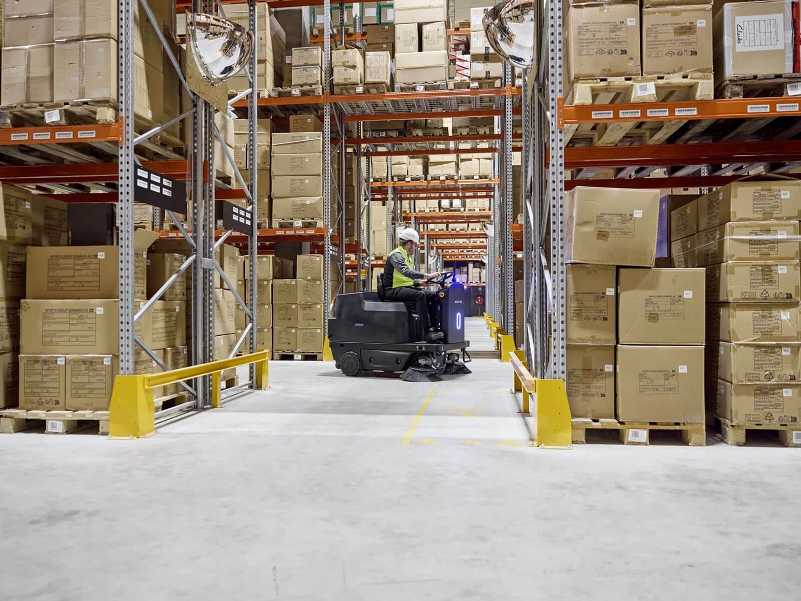 A warehouse filled with stacked boxes and a forklift in operation for inventory management.